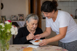 Ελληνίδα κόρη βοηθά ηλικιωμένη μητέρα στο σπίτι με καθημερινή φροντίδα